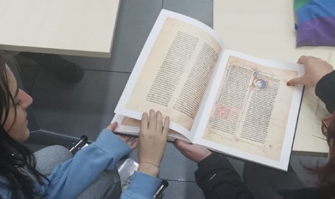 Dos alumnas examinan un ejemplar de encuadernado medieval